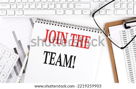 Text JOIN THE TEAM on Office desk table with keyboard, notepad and analysis chart on a white background.