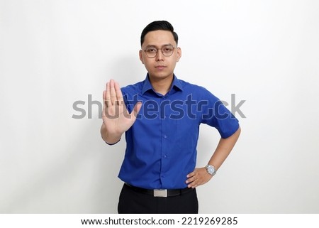Young asian man standing with stop hand gesture. Isolated on white background