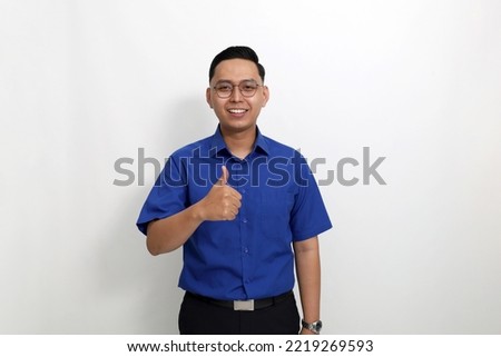 Happy young asian man standing while showing thumbs up. Isolated on white with copyspace