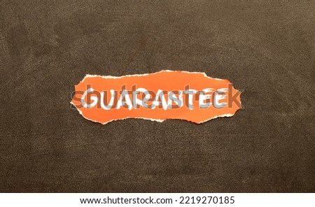 text of the word guarantee on wooden cubes. flowers in the background.