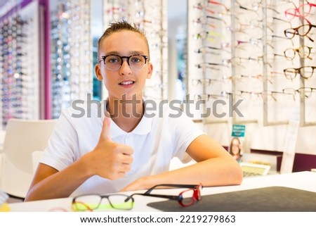 Young male client trying on new spectacles in medical shop