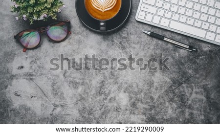 Dark Office desk with keyboard, pen, eyeglass and cup of coffee, Top view wth copy space, Flat lay.	

