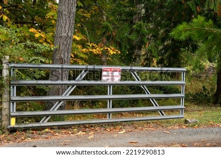 An image of a large metal gate with a red and white no trespassing sign posted.