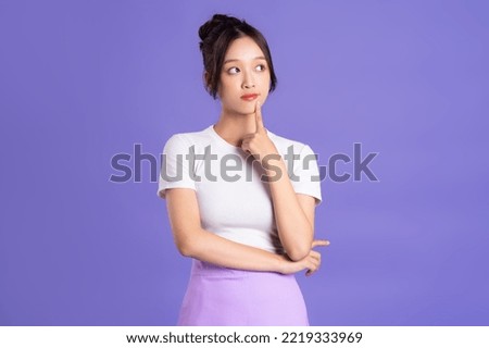 Portrait of a beautiful Asian woman posing on a purple background Royalty-Free Stock Photo #2219333969