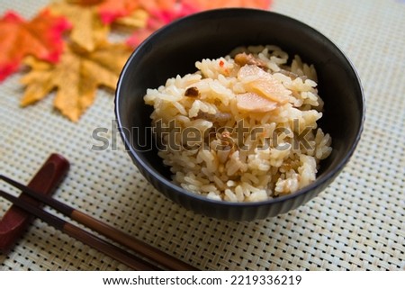 A picture of rice cooked with rice, chopsticks and autumn leaves from diagonally above