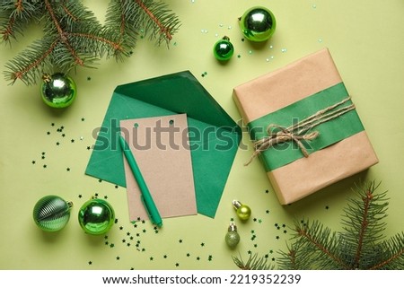 Blank card, Christmas gift, fir branches and decorations on green background