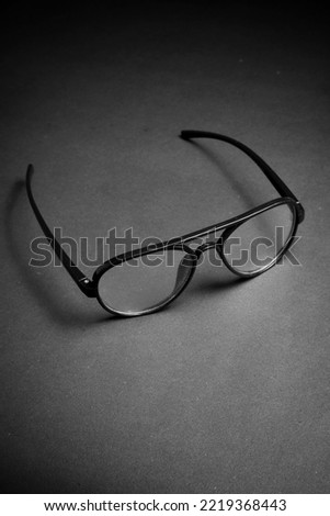 elegant black eyeglasses on the highlighted spot of dark black background