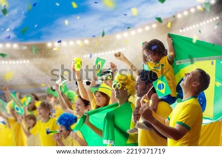 Brazil football supporter on stadium. Brazilian fans on soccer pitch watching team play. Group of supporters with flag and national jersey cheering for Brazil. Championship game. Royalty-Free Stock Photo #2219371719