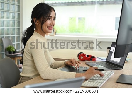Attractive woman photo editors retouching photos on personal computer, working in creative office