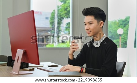 Professional creative man drinking coffee and working with computer in home office studio