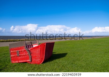A beach chair lies on its back in the grass on the North Sea coast
