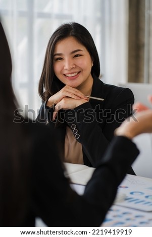 Two Asian business women meet to discuss finances and business information at a modern office.
Young people are consulting, analyzing plans, and working together using data from paper graphs.