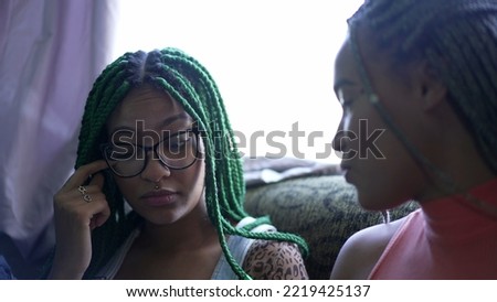 A young black woman rubbing eye with finger