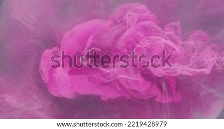 Ink water drop. Color smoke splash. Neon pink paint flow on purple glitter mist cloud abstract background.