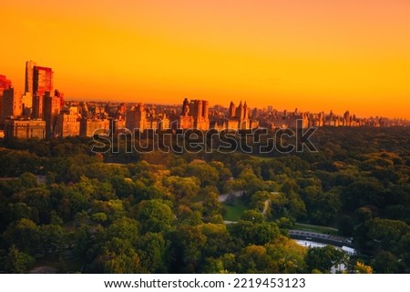 Aerial view of the Central park in Manhattan, New York with golf fields and tall skyscrapers surrounding the park. Sunset view. Travel and landscape concept.