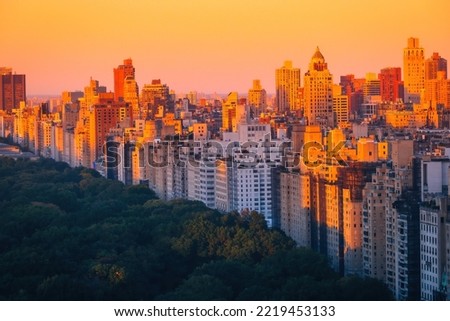 Aerial view of the Central park in Manhattan, New York with golf fields and tall skyscrapers surrounding the park. Sunset view. Travel and landscape concept.