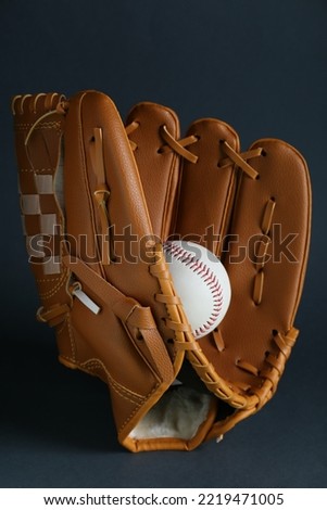 Catcher's mitt and baseball ball on dark background. Sports game