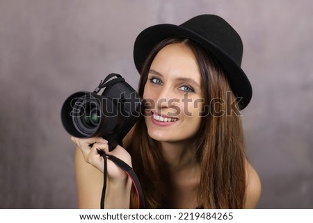 Beautiful woman with a photo camera in a hat, portrait of a photographer