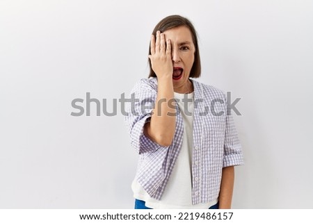 Beautiful middle age hispanic woman standing over isolated background doing stop sing with palm of the hand. warning expression with negative and serious gesture on the face. 