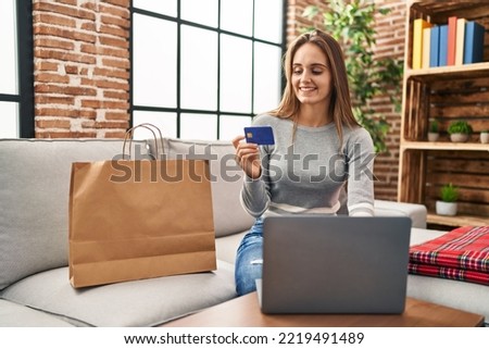 Young blonde woman smiling confident shopping online at home