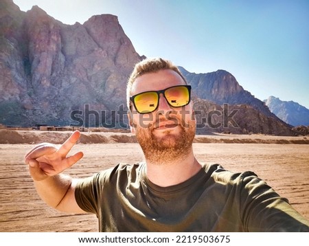 Young man taking selfie at desert location - Travel concept with happy guy on adventure vacation