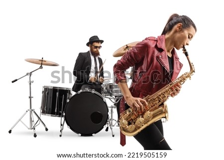 Young female playing a saxophone and a man playing drums in the back isolated on white background