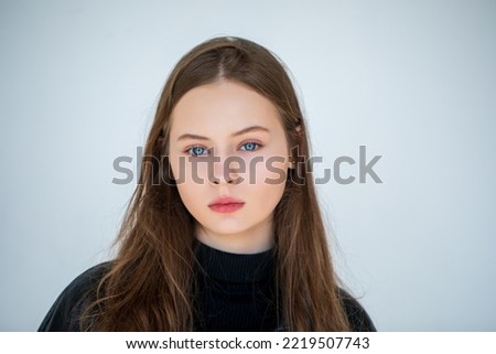 Portrait of a beautiful young teen girl with blue eyes on a light background. natural beauty white skin.        