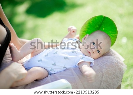 Mom supports and tenderly cuddles the newborn baby gently while the infant is lying on the lap
