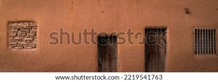Abstract geometry of southwestern Adobe Earth tone stucco wall with doors and windows 