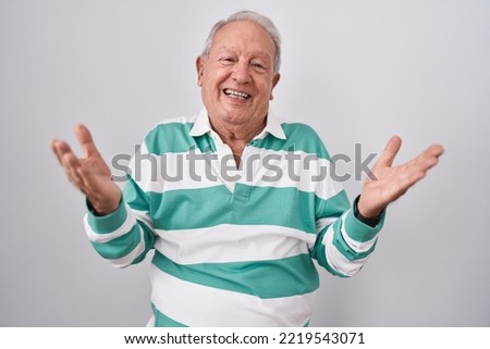 Senior man with grey hair standing over white background smiling cheerful offering hands giving assistance and acceptance. 