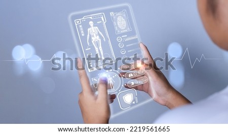 Female doctor's hand pokes at a medical icon harogram. medical concepts, treatment, medical technology, medical application Royalty-Free Stock Photo #2219561665