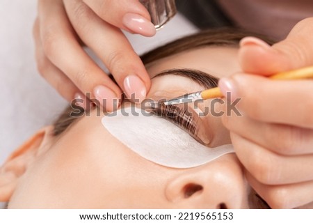 Make-up artist makes the procedure of lamination and dyeing of eyelashes to a beautiful woman in a beauty salon. Eyelash extensions. Eyelashes close-up Royalty-Free Stock Photo #2219565153