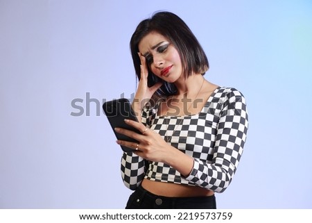 Young beautiful girl in a black and white shirt on a stressful phone call, expressive emotions and gestures of a tensed girl