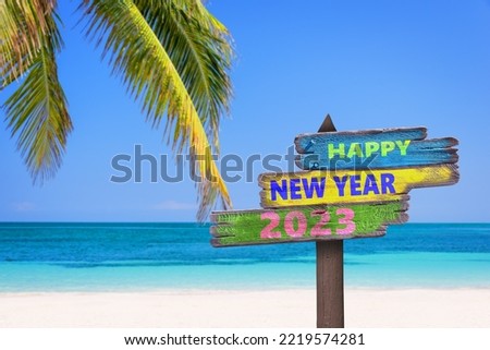 Hapy new year 2023 written on direction signs, tropical beach background, travel and tourism greeting card