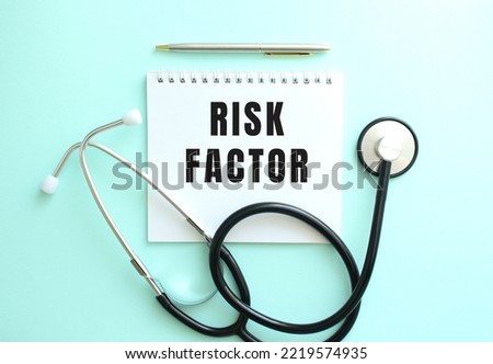 White notepad with the words RISK FACTOR and a stethoscope on a blue background.