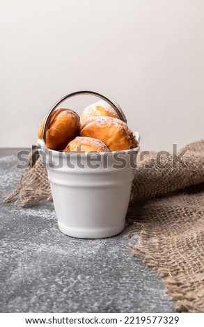 Baursak - Traditional Kazakh Asian in a white bucket. Beautiful presentation of the food. yeast dough balls, prepared on a pan with oil and sprinkled with powdered sugar