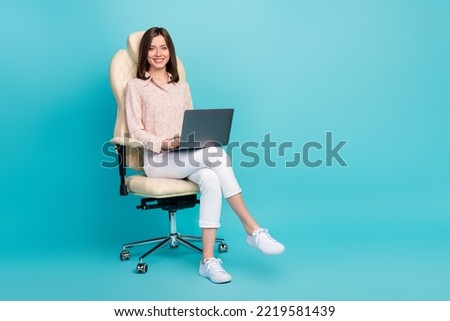 Full length size photo of successful cute businesswoman sitting chair smiling use laptop trader empty space ad company isolated on blue color background