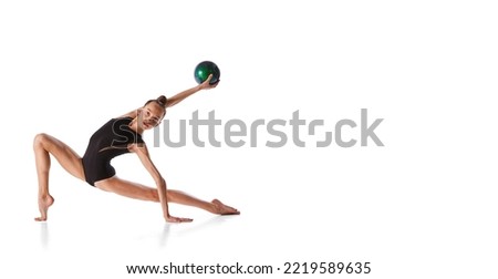 beauty and grace. Portrait of junior gymnast in black sport swimsuit doing gymnastics excercises isolated over white background. Sport, skills, achievements. Flyer for ad