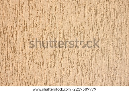 Texture of decorative plaster with a relief. Beige plaster. Close-up. Royalty-Free Stock Photo #2219589979