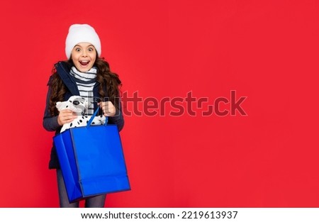 amazed kid in puffer jacket and hat. teen girl after shopping
