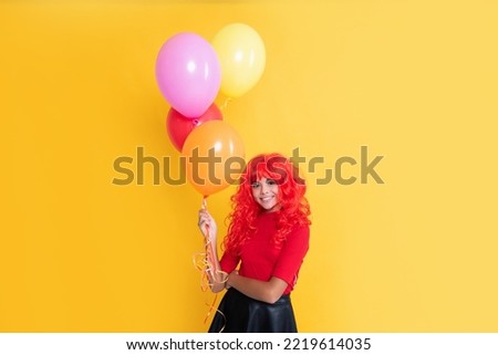 glad child with party balloon on yellow background