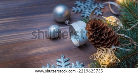 Christmas composition with fir branches and christmas decorations, garland on a wooden table. Winter holiday background with copy space