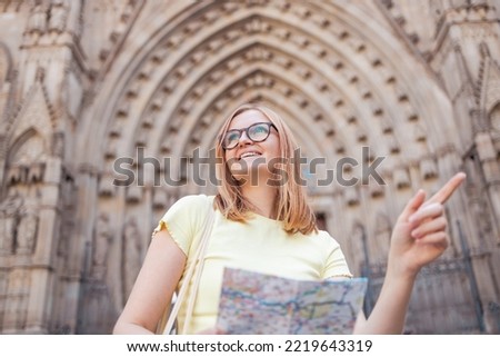 Young optimistic woman tourist happy traveller in glasses and stylish clothes making selfie photo in front of the famous the old Barri Gothic Quarter in Barcelona, Spain