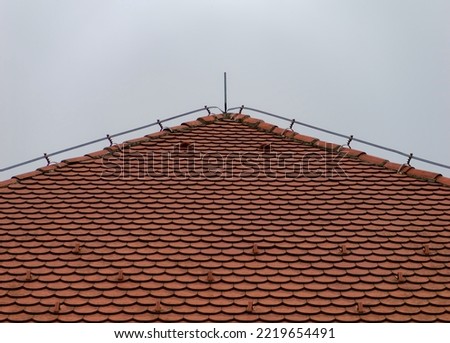 Red roof tile with a bright sky in the background