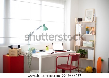 Cozy interior teenage person room with desk, chair and education supplies - Youth lifestyle concept Royalty-Free Stock Photo #2219666237