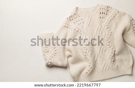 Winter sweater on concrete background, top view.