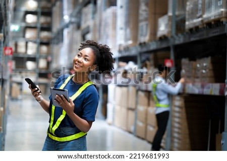 Young happiness black worker looking for boxes on shelves with smile face to find the shipment order online system on tablet,smartphone in hands, warehouse application. Delivery logistic business Royalty-Free Stock Photo #2219681993