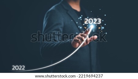 Businessman hand drawing line for increasing arrow from 2022 to 2023 for preparation merry Christmas and happy new year concept. new business, start up on new years.