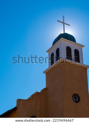 St Joseph Catholic Church Spier with the cross illuminated by the sunlight in Los Cerrillos in the County of Santa Fe, New Mexico, USA Royalty-Free Stock Photo #2219696667