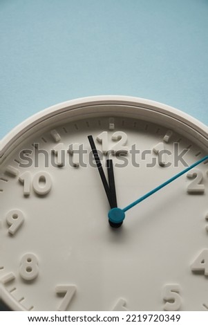 wall clock at 12 o'clock against blue background